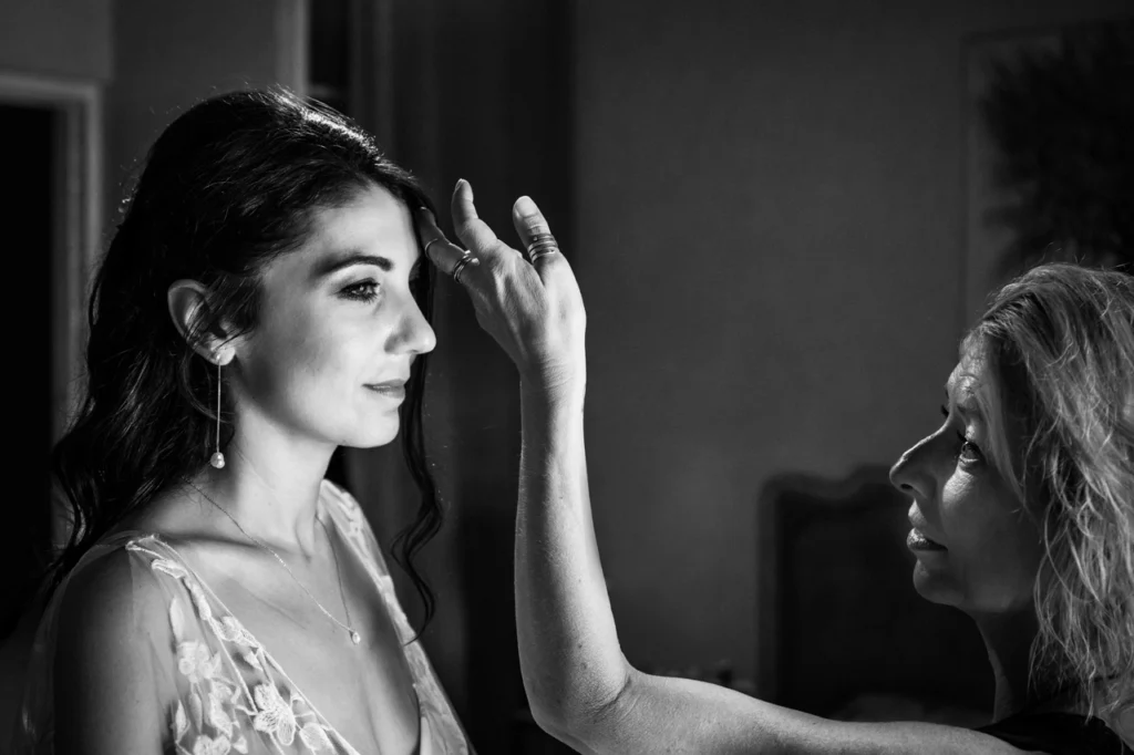 La maquilleuse procède aux derniers ajustements lors des préparatifs de mariage