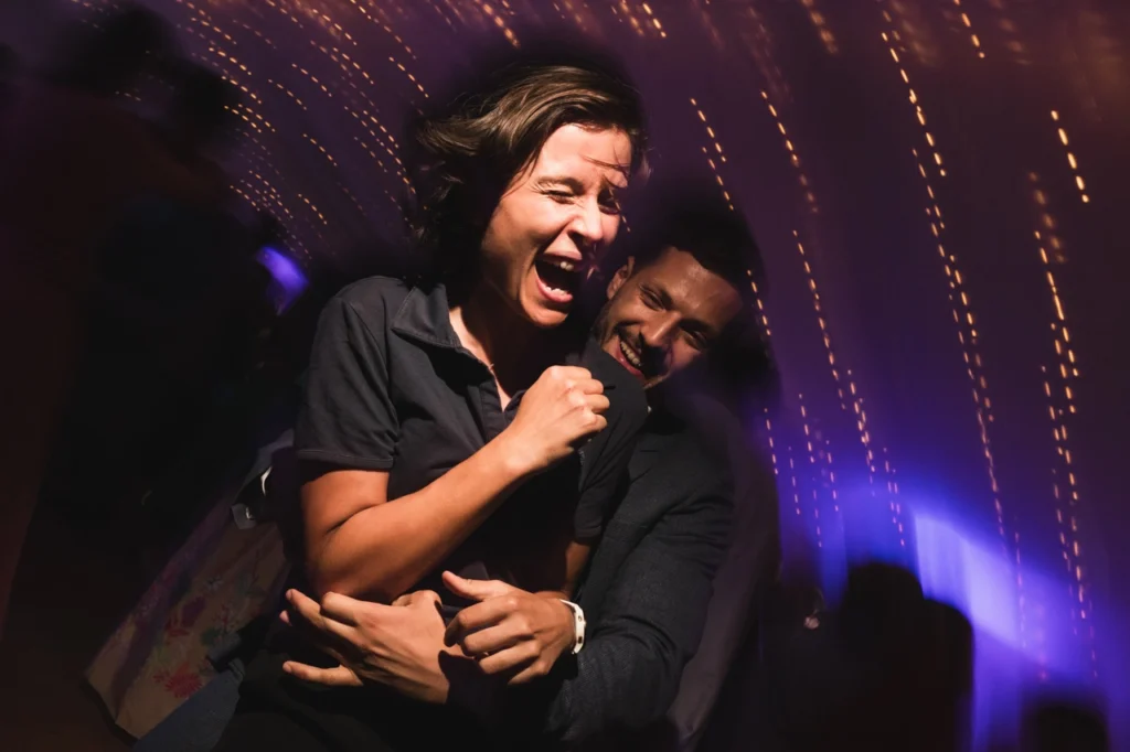 Les convives du mariage sont photographiés au flash pendant qu'ils dansent