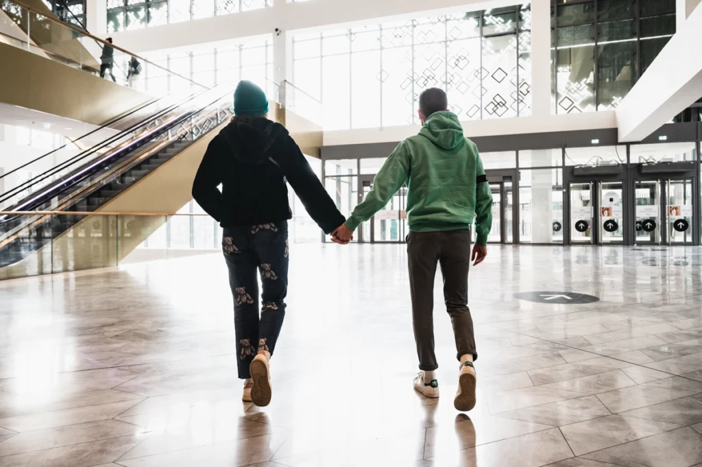 Un couple marche main dans la main dans le centre commercial Westfield la Part-Dieu à Lyon